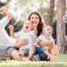 Joyful family enjoying a sunny day in the park while playing with bubbles.